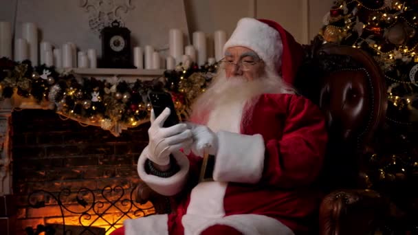 클로스가 스마트폰으로 크리스마스 선물을 인터넷에서 구매하는 벽난로 크리스마스 받으세요 할아버지는 — 비디오