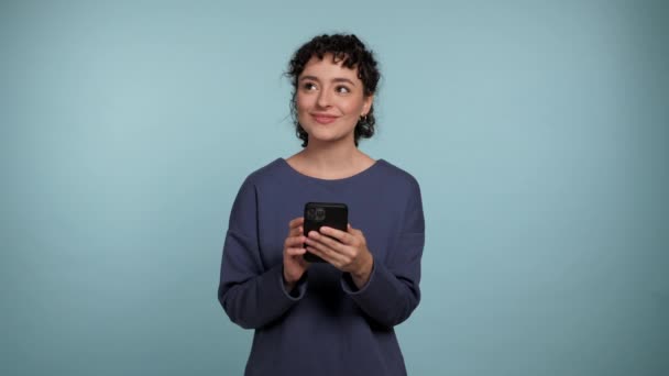 Mujer Rizada Sonriente Usando Teléfono Inteligente Escribiendo Navegación Pensando Comprar — Vídeo de stock