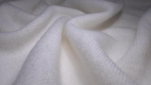 Hangulatos juhok gyapjú fehér színű szövet textúra makró. Kézműves kötött gyapjú pulóvert. Puha textil elvont háttér. Téli divat ruhaipar. Otthoni kényelem és kényelem — Stock videók
