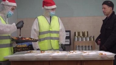 Fakir ve evsizler için Noel arifesi. Covid-19 ve Noel zamanı evsizler barınağı. Yetersiz beslenen insanlar için gönüllü yemek paketleri. Yiyecek bankası, bağış kutusu, sıcak öğle yemekleri. Bağış, Geri Ver
