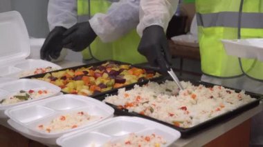 Fakir ve evsizler için Noel arifesi. COVID-19 salgınının ortasında gıda bankaları. Yemek bankasında gönüllü olarak çalışan insanlar, ihtiyacı olanlara ücretsiz sıcak yemek veriyorlar.