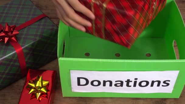 Liefdadige kerstcadeaus voor kinderen, gezinnen en senioren uit huishoudens met een laag inkomen. Vrijwilliger helpt weeskinderen om geschenken te krijgen tijdens de feestdagen. Donatiebox, hulp tijdens Covid-19 — Stockvideo