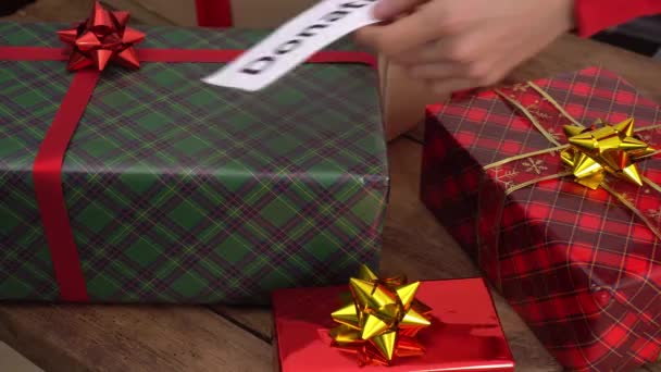 Organismes de bienfaisance qui aident les enfants à Noël. Un bénévole emballe et distribue des coffrets-cadeaux aux enfants dans le besoin — Video