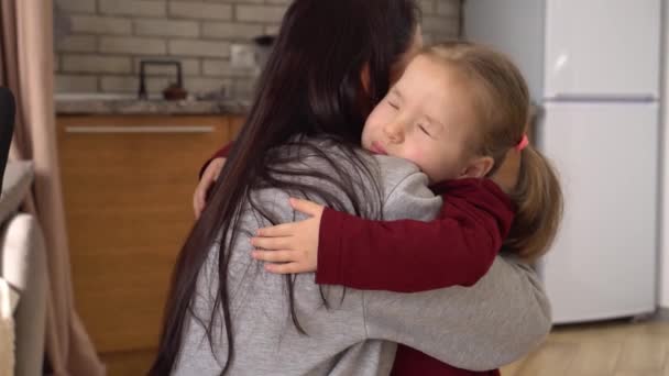 Smutná dcera objímající matku doma. Pohled zpět Bruneta maminka s jejím dítětem, malá dívka s frustrovanou tváří objímající mladou ženu — Stock video