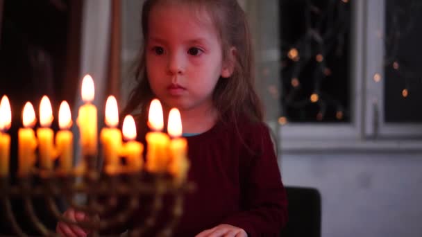 Chanukka. Kind betrachtet Menorah-Kerzen. Die Beleuchtung einer Menora und ein jüdischer Feiertag. Chanukka, Chanuka, Chanukka, Hanuka — Stockvideo