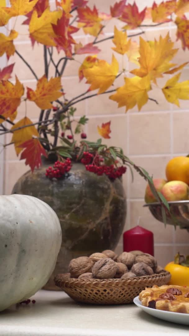 Le jour de Thanksgiving. Fête de la récolte. Sur la table il y a une tarte à la citrouille avec des légumes mûrs et des fruits et un décor de feuilles et de fleurs d'automne — Video