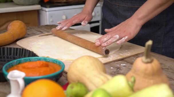 Een vrouw kneed deeg en kookt een Amerikaanse pompoentaart voor Thanksgiving diner — Stockvideo