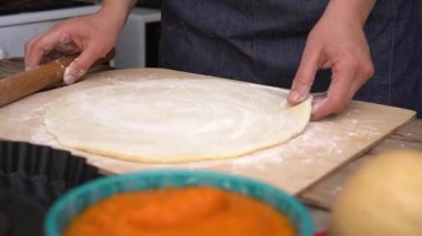 Bir kadın balkabağı turtası pişirir. Şükran Günü yemeği için ev yapımı geleneksel kabak turtası. Ev hanımı mutfakta hamur toplar. Kırsal sonbahar dekoru