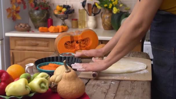 En kvinna bakar pumpapaj. Hemlagad traditionell Pumppaj till Thanksgiving-middag. Hemmafrun rullar ut stålar i köket. Höstens heminredning — Stockvideo