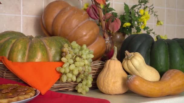 Thanksgiving dag. Oogstfestival. Op tafel ligt een pompoentaart met rijpe groenten en fruit en een decor van herfstbladeren en bloemen. Herfstdecoratie — Stockvideo