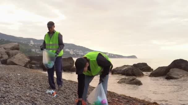 使用过的医疗面罩污染了海滩和海洋。Covid-19大流行病期间和之后的塑料废物。志愿人员清理海滩和海滨 — 图库视频影像
