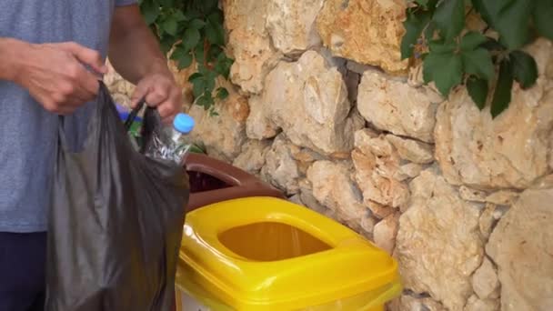 Sokaktaki çöpleri ayırmak için renkli çöp kutuları. Plastik çöp kutusu. Plastik, cam, kağıt ve metal atıklarının toplanması, geri dönüşümü ve yeniden kullanımı. Atık yönetim sistemi — Stok video