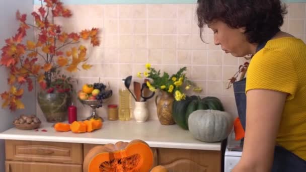 A farmer woman cooks homemade pumpkin pie, cuts pumpkin, kneads dough. Celebrating Thanksgiving and Harvest Festival at home with family — Stock Video