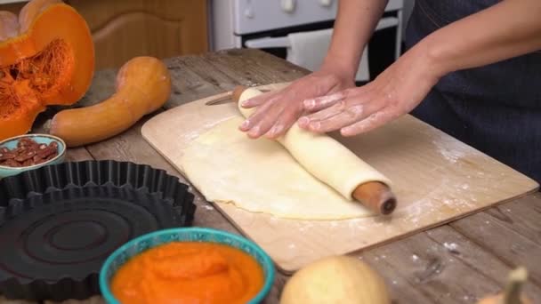 Thanksgiving with family. The hands of a farmers woman roll out the dough for an American pumpkin pie — Stock Video