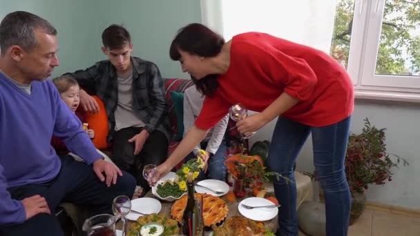 A mãe feliz põe a mesa festiva. Família autêntica. Celebrar as férias em conjunto com as crianças em casa. Refeições caseiras festivas tradicionais em cima da mesa. Alimentos e bebidas — Vídeo de Stock