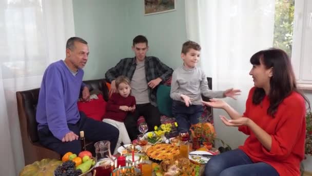 Glad autentisk uppriktig familj med barn som äter middag hemma. Julen. Thanksgiving Hanukkah jul. Festlig mat vid bordet. Mor skär kalkon — Stockvideo