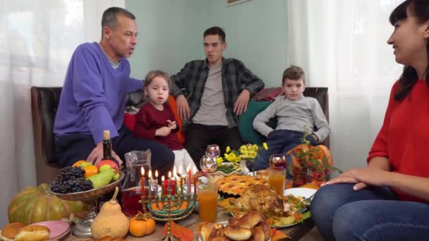 Família judia ter um jantar juntos em casa. Hanukkah menorah. Comida tradicional kosher festiva na mesa — Vídeo de Stock