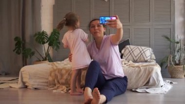 Çevrimiçi Tatil Selamları. Mutlu gülümseyen anne ve kız internet üzerinden akıllı telefon kullanarak iletişim kuruyor. Görüntülü konuşma. Sosyal uzaklık, evde kal, kilitle.