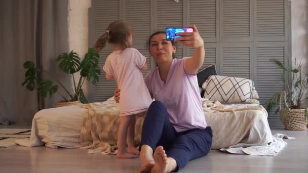 Online Holiday вітання. Щаслива мати і дочка спілкуються через відео-посилання в Інтернеті за допомогою смартфона. Відео базікання. Суспільна дистанція, залишайся вдома, замкнений — стокове відео