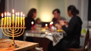 Mutlu Yahudi ailesi akşamları Hanuka bayramını kutlamak için birlikte yemek yer. Hanuka menorası. Işıklar Festivali