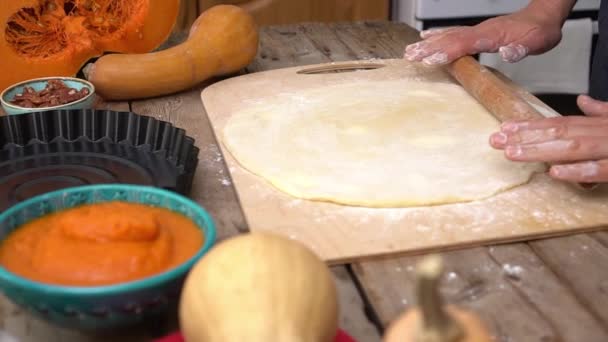 Eine Frau backt Kürbiskuchen. Hausgemachter traditioneller Kürbiskuchen zum Thanksgiving-Dinner. Hausfrau rollt Teig in der Küche aus. Herbstliche Wohnungsdekoration — Stockvideo