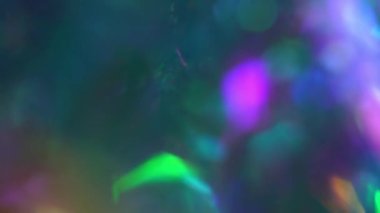 Noel için holografik arka plan ve mutlu yıllar. Bokeh dolusu neon lamba ve Noel ağacı ışıkları parlıyor. Gökkuşağı renginde parlak tatil dokusu
