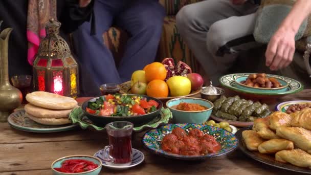 Familia musulmana de Oriente Medio comiendo juntos. Ayuno, oración e iftar durante el Ramadán en encierro. Comida tradicional oriental y asiática sobre la mesa — Vídeos de Stock