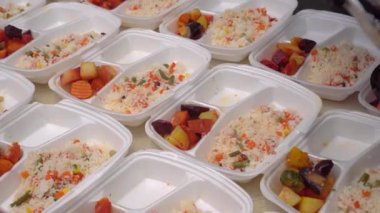 Gönüllü, Noel yemeklerini konteynırlarda bedavaya paketliyor. Tatil sepeti dolusu yiyecek. Hayır kurumları, kiliseler, halk çorbacıları ve restoranlar fakir ve muhtaçlara yemek servisi yapıyor.