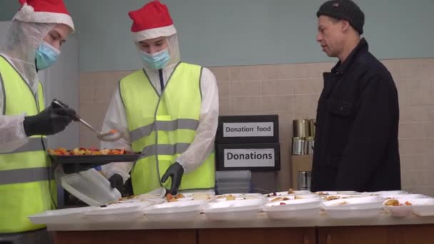 Kerst Voedsel bank voor armen en daklozen. Dakloze opvang tijdens Covid-19 en Kerstmis. Vrijwilligerswerk maaltijden voor ondervoede mensen. Donatiebox, Hot lunches, Donatie — Stockvideo