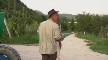 Bir çiftçi meyve bahçesinde şeftali hasadı topluyor. Meyve toplama mevsimi. Baba ve kızı çiftçi pazarına bir kutu mahsul taşıyor.