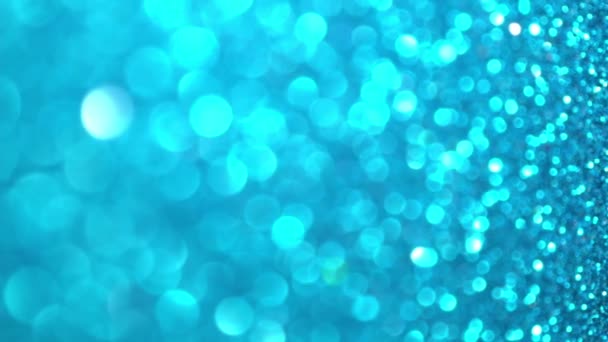 Blauwe Glitter achtergrond. Lichte bokeh, magische kerstverlichting, glanzende textuur, vakantielichten, vliegende deeltjes vormen een mooie bokeh. Schitterende feestelijke kerst achtergrond. Verticale video — Stockvideo