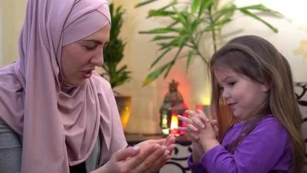 Madre musulmana in hijab insegna la preghiera a sua figlia. Educazione religiosa — Video Stock