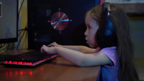 Un bambino con le cuffie gioca un videogioco online sul computer. Il problema della dipendenza dai giochi per computer nei bambini — Video Stock