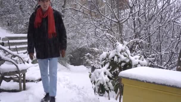 Ένας νεαρός το χειμώνα, γλιστράει στο χιόνι και πέφτει. Γλιστρητό πεζοδρόμιο, πάγος — Αρχείο Βίντεο