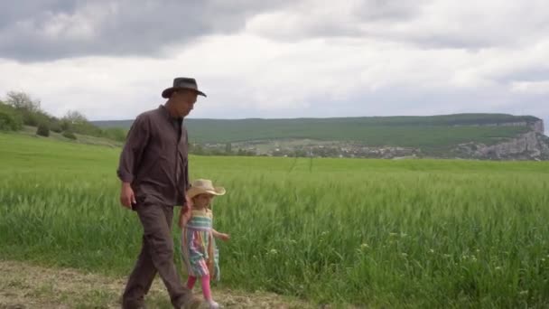 행복 한 어린 딸을 둔 농부인 아버지는 봄이 되면 푸른 밀밭을 살핍니다. 가족 유기 농업 사업. 마을에서의 생활. 농업 산업 수확 개념 — 비디오