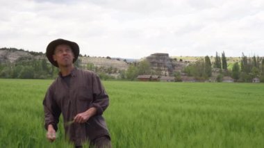 A worried middle-aged farmer looks up at the sky in anticipation of rain. Growing Wheat, crop failure. Rainy or typhoon season.