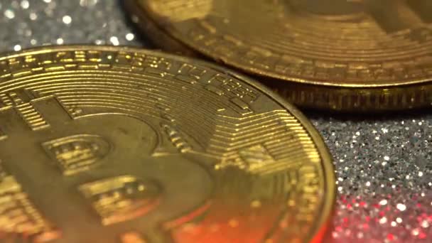 Bitcoin-Münzen werden in Nahaufnahme mit einem alarmierend blinkenden roten und blauen Licht beleuchtet — Stockvideo