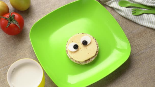 Food Art snack gyerekeknek. Aranyos arc egy tányéron. Egy anya egészséges reggelit készít egy gyereknek. — Stock videók