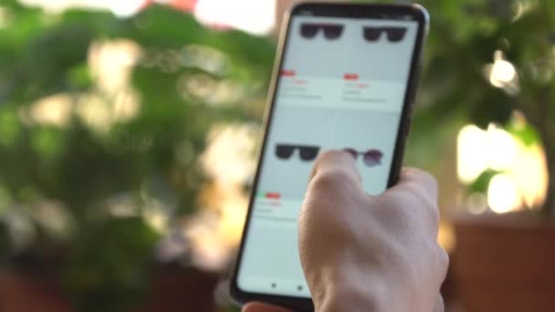 En man hemma Använda Smartphone Köper i Internet Shop. Beställningar Solglasögon I en webbutik Använda en smartphone. Handla på nätet — Stockvideo