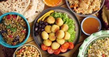 Ramazan tarifi. Falafel, bezelye ezmesinden yapılmış bol yağda kızartılmış bir toptur. Falafel geleneksel bir Orta Doğu yemeğidir. Falafel topları salata, sebze ve acı sosla kaplı.