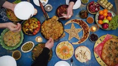 Ramazan Kareem. Yemek masası manzaralı iftar. Mutlu otantik Arap Müslüman ailesi mutfakta birlikte yemek yiyor. Din kavramı, yaşam tarzı, sosyal, aile. Yavaş Hareket