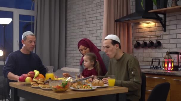 Ramazan ayının kutsal aylarında iftar sırasında servis edilen yemek masası. Geleneksel Müslüman aile evde yemek yiyor. — Stok video