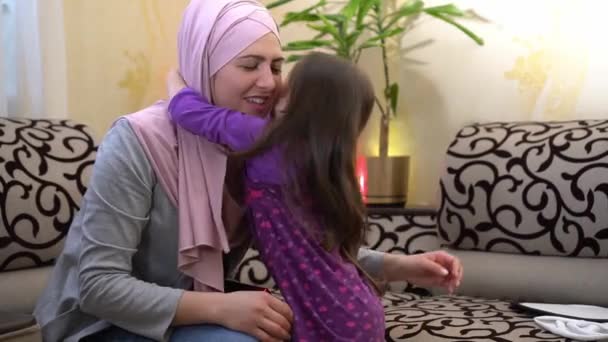 Dcera objímá svou muslimskou maminku v hidžábu doma — Stock video