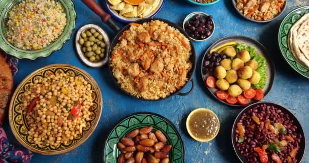 Hagyományos Halal közel-keleti konyha. Falafel, samosa, csicseriborsó, bab, pitakenyér, pilaf, tajine, kuszkusz, datolya, olívabogyó. Eid Al Fitr ünnep ünnepe — Stock videók