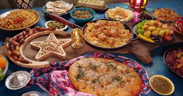 Традиционные блюда для обслуживания во время Рамадана - Фалафель, самоса, горох, бобы, хлеб из питы, плов, таджин, кускус, финики, оливки. Накрытый стол для празднования Ид аль-Фитр. Семейный ужин — стоковое видео