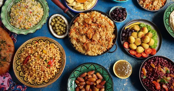 Hagyományos Halal közel-keleti konyha. Falafel, samosa, csicseriborsó, bab, pitakenyér, pilaf, tajine, kuszkusz, datolya, olívabogyó. Eid Al Fitr ünnep ünnepe — Stock Fotó