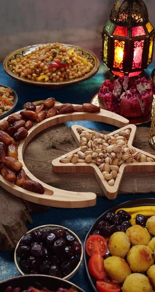 Kareem Ramadan avec des dates, des noix et des bonbons disposés en forme de croissant de lune islamique et étoile. Concept alimentaire Iftar, table de vacances — Photo
