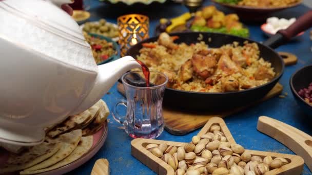 Moroccan mint tea. Ramadan iftar Eid. Muslim family has dinner at home. Falafel, samosa, chickpeas, beans, pita bread, pilaf, tajine, couscous, dates, olives. Eid Al Fitr holiday celebration — Stock Video