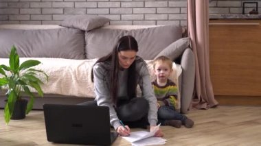 Küresel ekonomik kriz ve yaptırımlar. Evde çocuklu endişeli bir anne aile bütçesini koruyor. Aylık gelir ve giderlerin hesaplanması, kamu hizmetleri, fatura, kredi