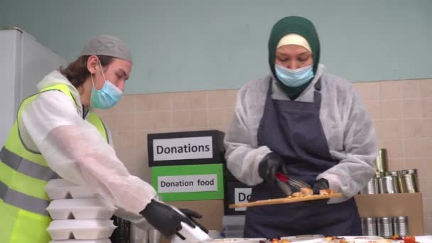 Muslimští dobrovolníci balí teplá jídla zdarma do krabic. Darování jídla a charita na Ramadánu. Prázdninová večeře a jídlo. Volný potraviny pro chudé lidi — Stock video